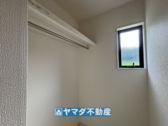 洗面室横にはパイプハンガーがある収納スペースがあります